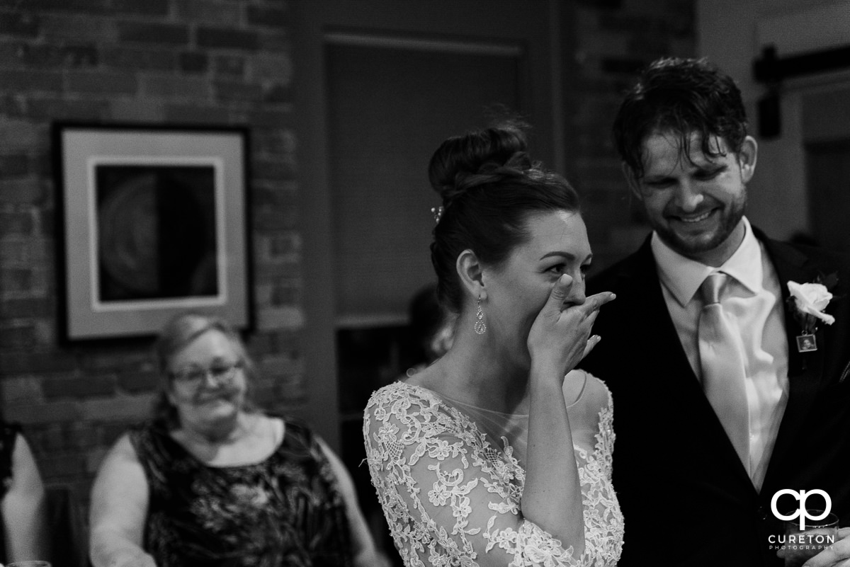 Bride laughing at a wedding speech.