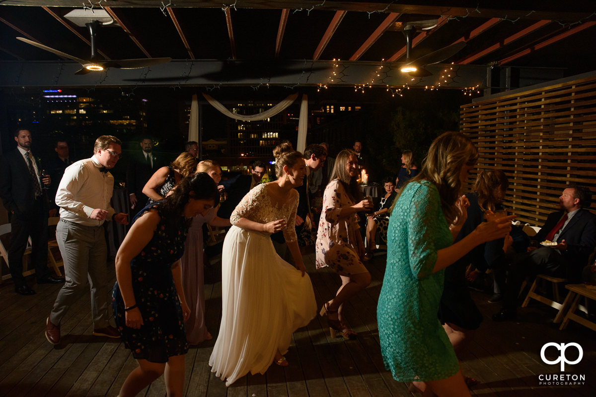 Guests dancing at the wedding reception on the rooftop at Soby's Loft in Greenville,SC.