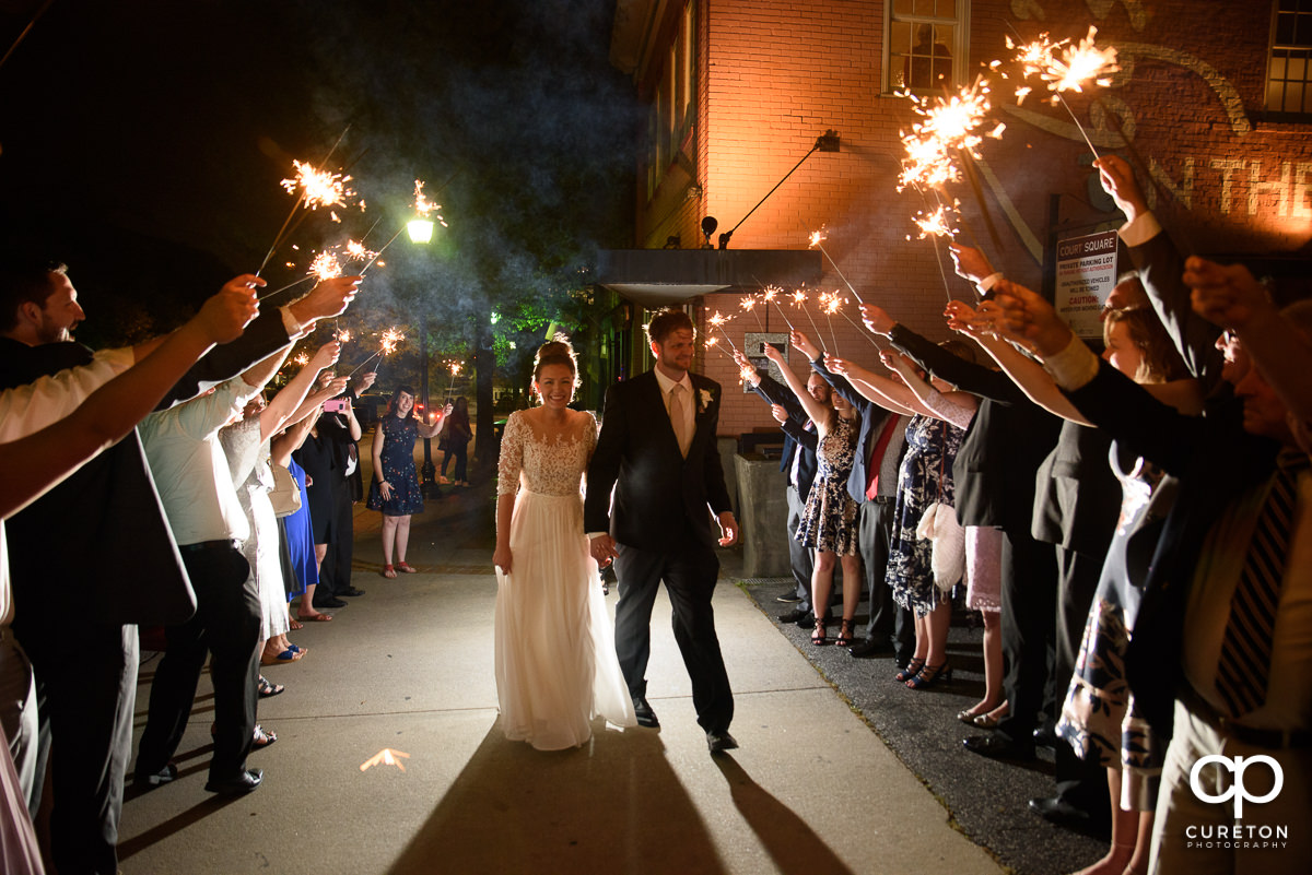 Bride and groom making a grand exit with sparklers at the reception.