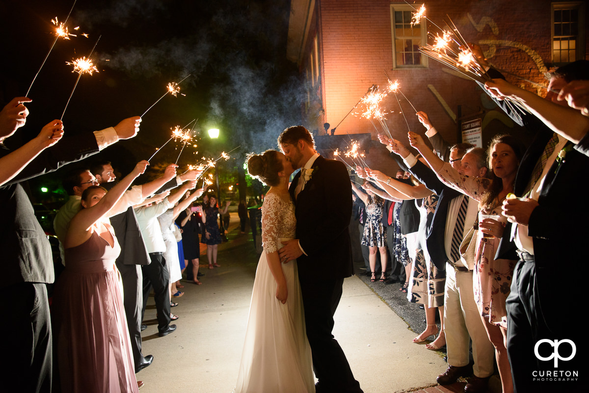 Bride and groom making a grand exit with sparklers at the reception.