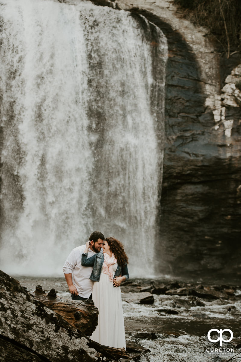Bride and groom dancing in a waterfall during their Looking Glass Falls engagement session in the Pisgah Forest of North Carolina.