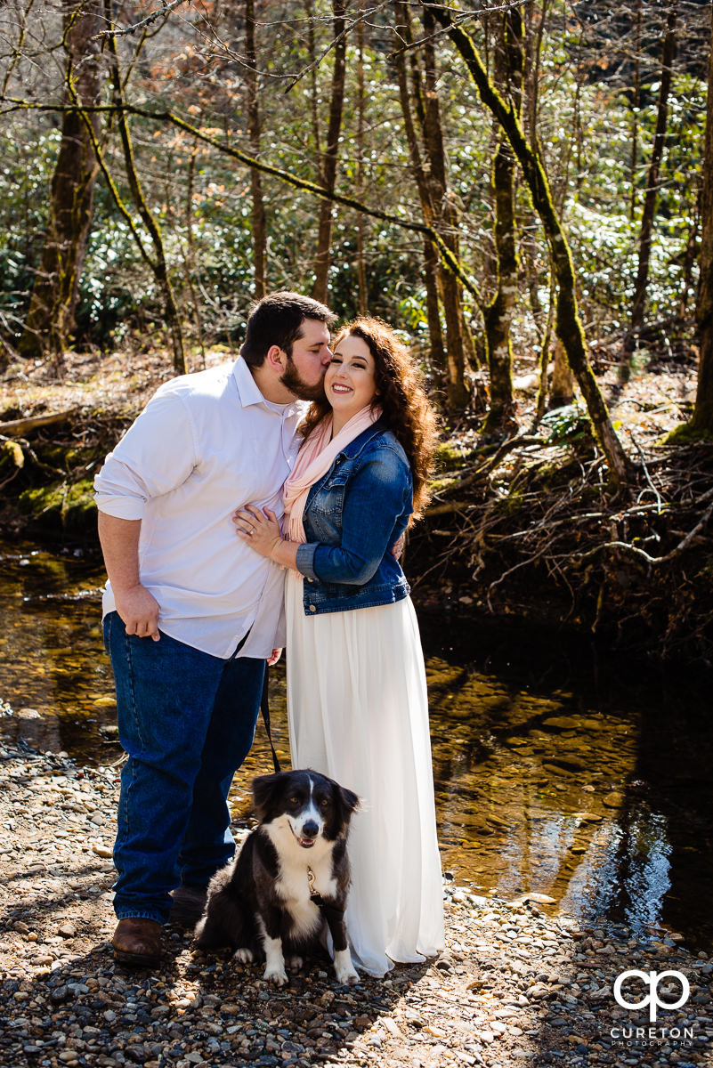 Bride and groom and their dog by the river in Pisgah Forest.