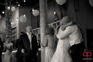 Bride and father hugging.