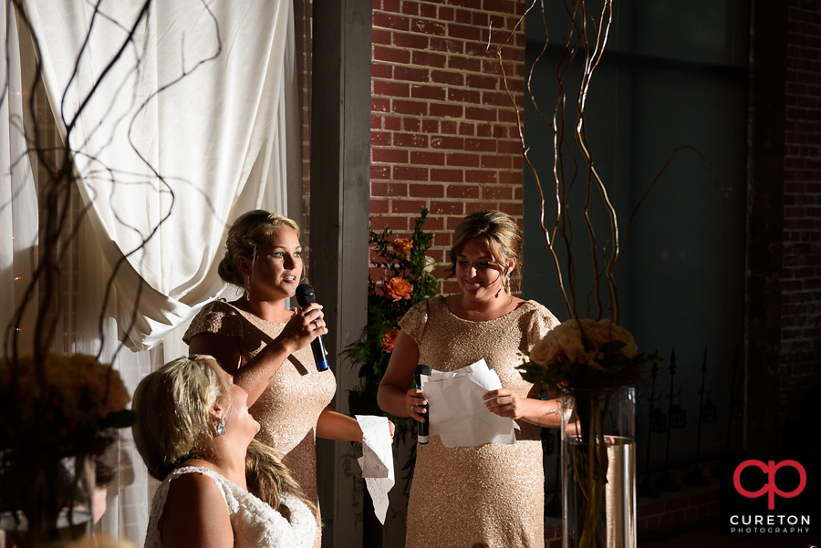 Bride's sisters sing a song for the bride.