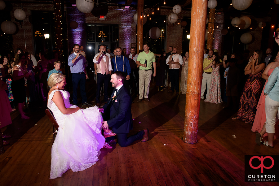 Groom taking off the garter.