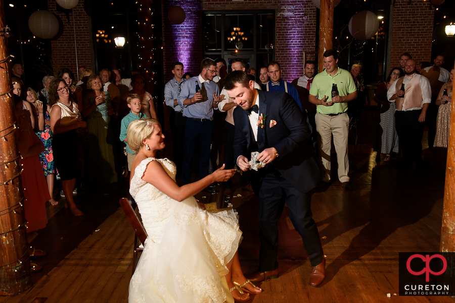 Groom taking off the garter.