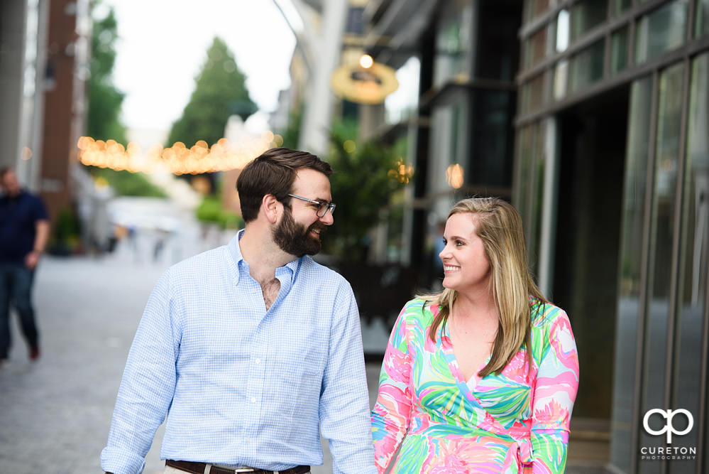 Engaged couple walking down the streets in downtown Greenville.