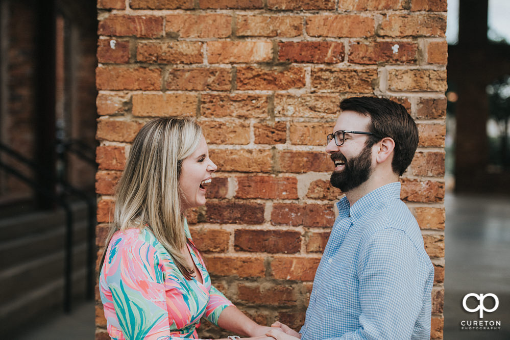 Bride and groom laughing during a Main Street Greenville SC engagement session.