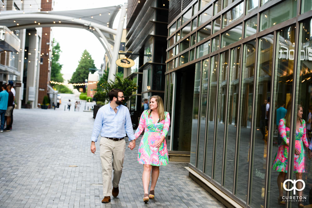 Engaged couple strolling in downtown Greenville.