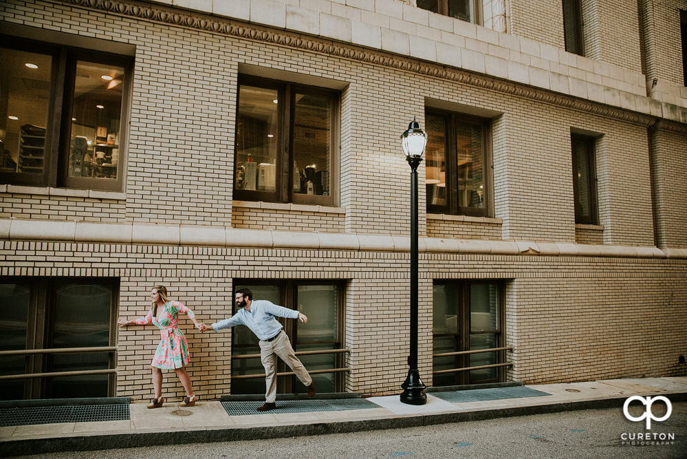 Bride and groom during an engagement session on Main Street Greenville,SC in front of the Westin Poinsett.