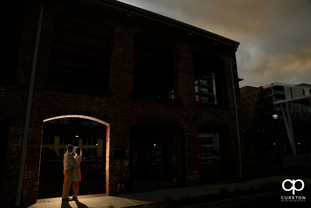 Future bride and groom hugging at the Wyche Pavilion off of Main Street Greenville during their engagement session.