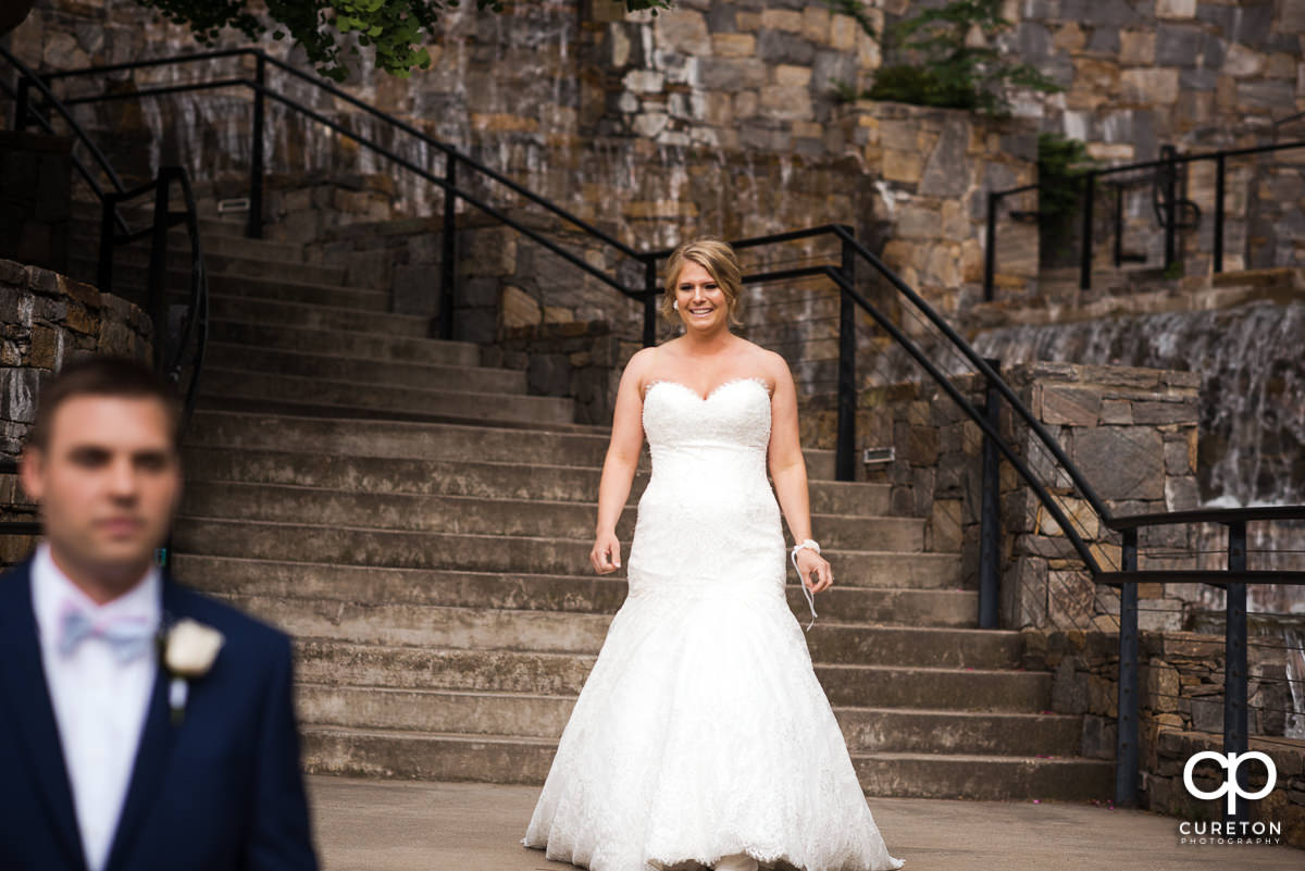 Bride preparing to sneak up on her groom at a pre-wedding first look in downtown Greenville.