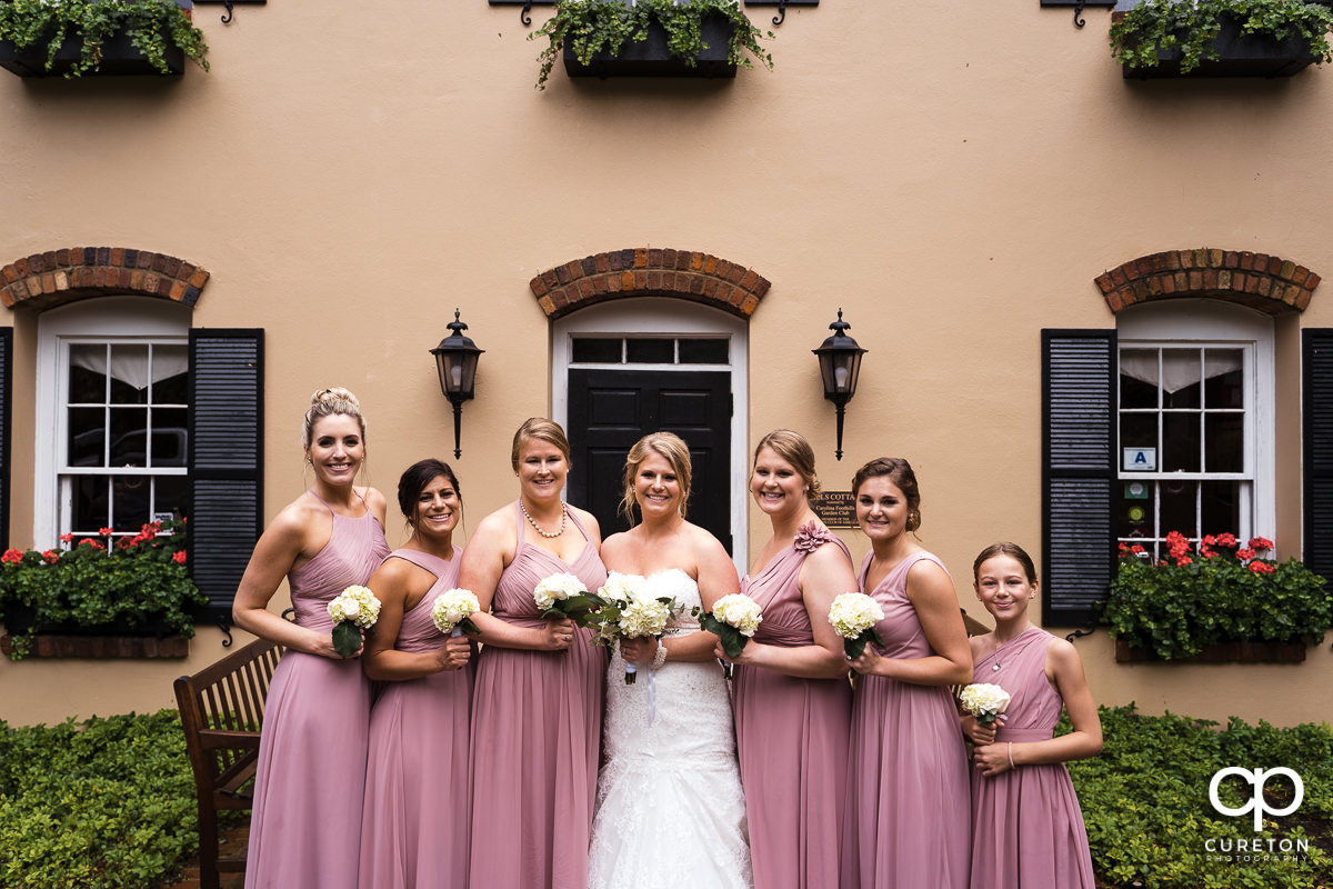 Bride and bridesmaids showing off their flowers.