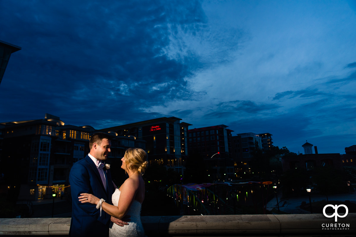 Bride and groom in front of a downtown Greenville,SC skyline at night.