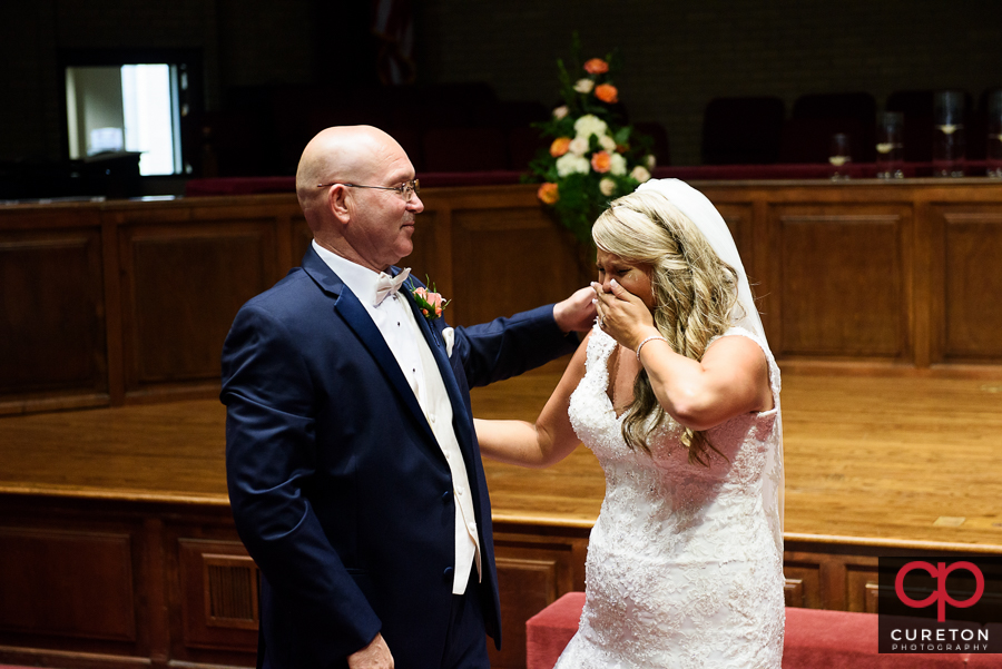 Bride and father first look inside church.