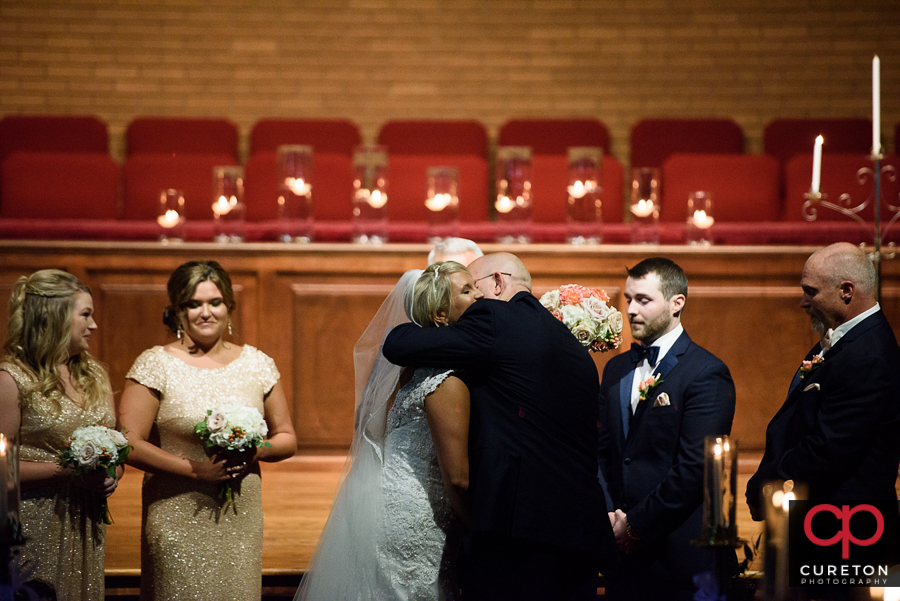 Bride's father hugging his daughter.