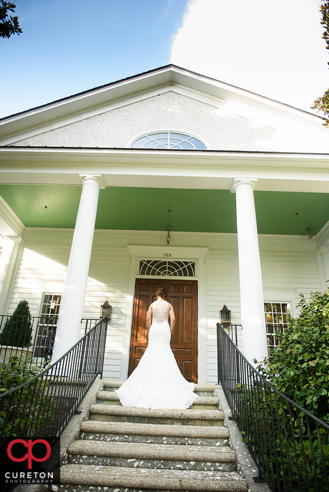 Brides standing on the steps of a house with pretty columns.