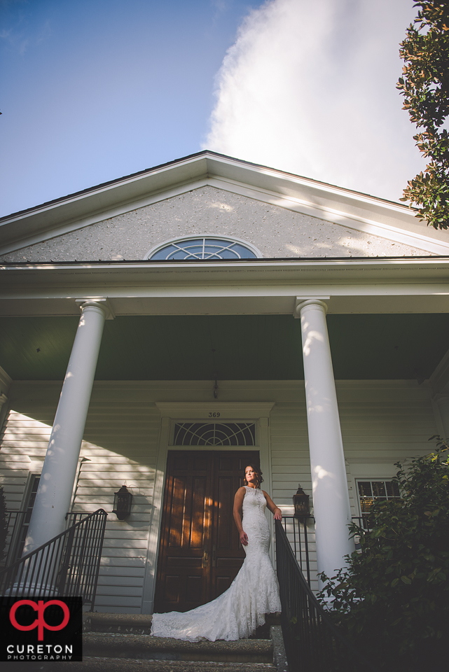 Bride standing on antebellum style house steps.