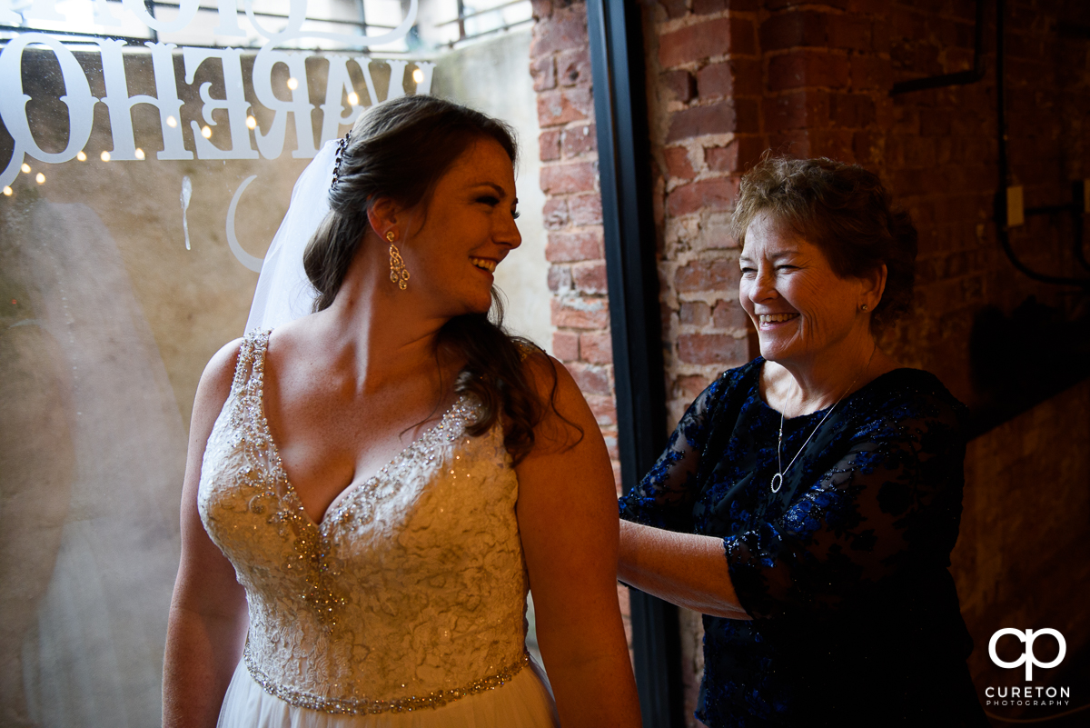 Bride's mother helping her into the dress.