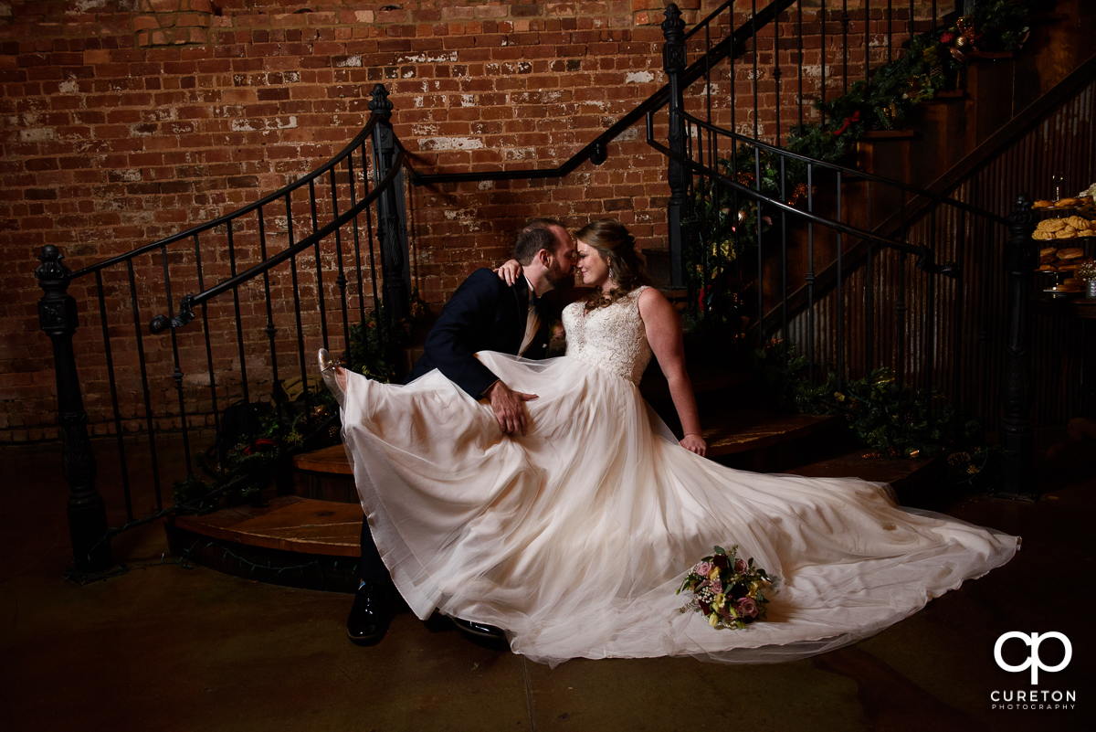 Bride and groom in an epic pose on the staircase at the old cigar warehouse.