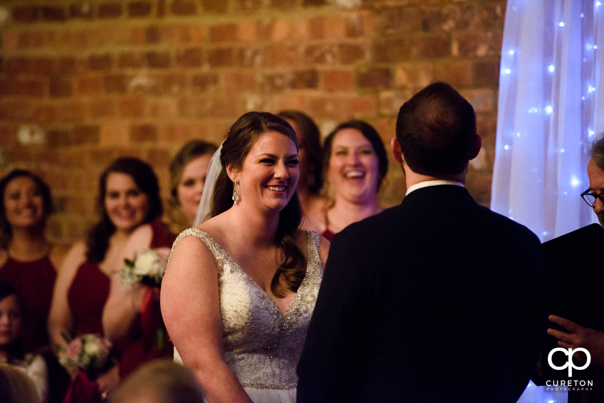 Bride laughing at her groom during the ceremony.