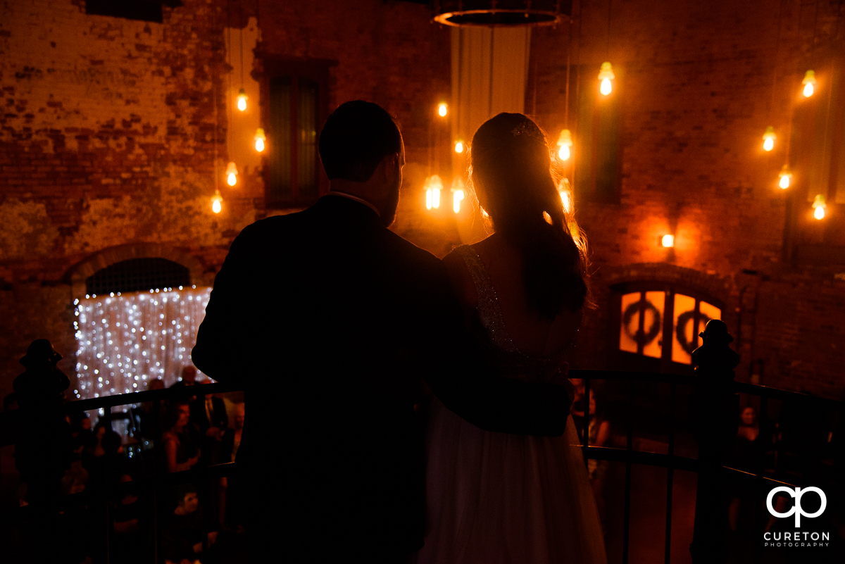 Bride and groom looking over their reception at The Old Cigar Warehouse.