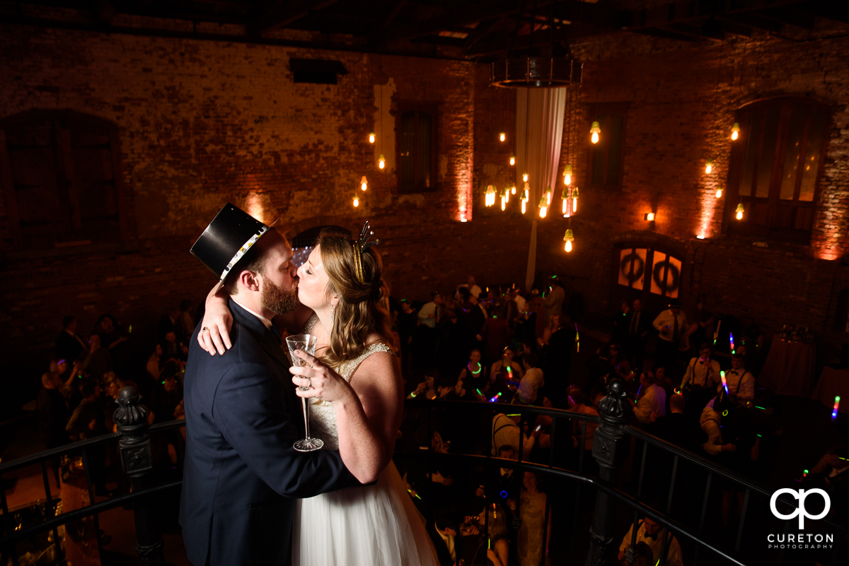 Bride and groom sharing a New Years Eve kiss at their wedding.