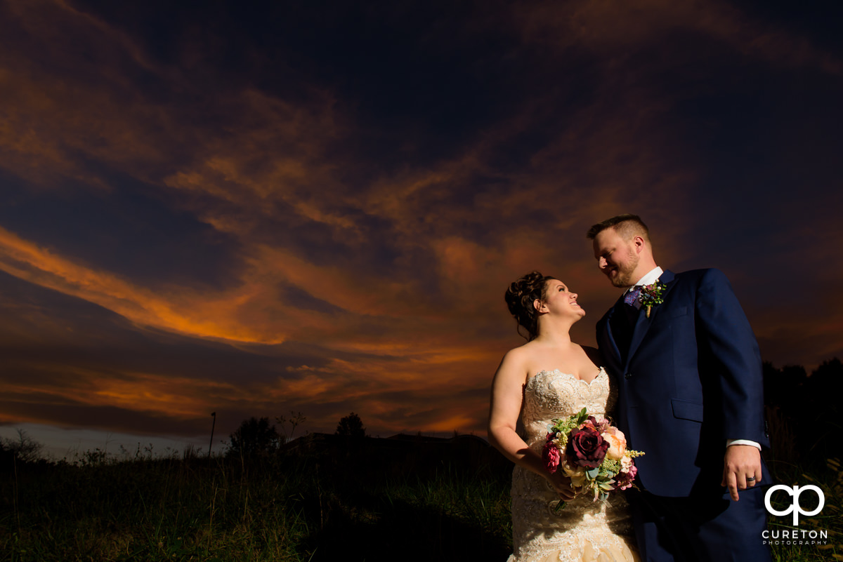 Bride and groom looking at each other at sunset at their Noah's Event Venue wedding.
