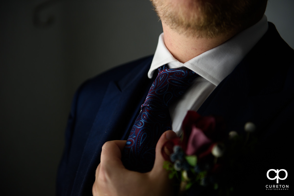 Groom holding his tie before the wedding.