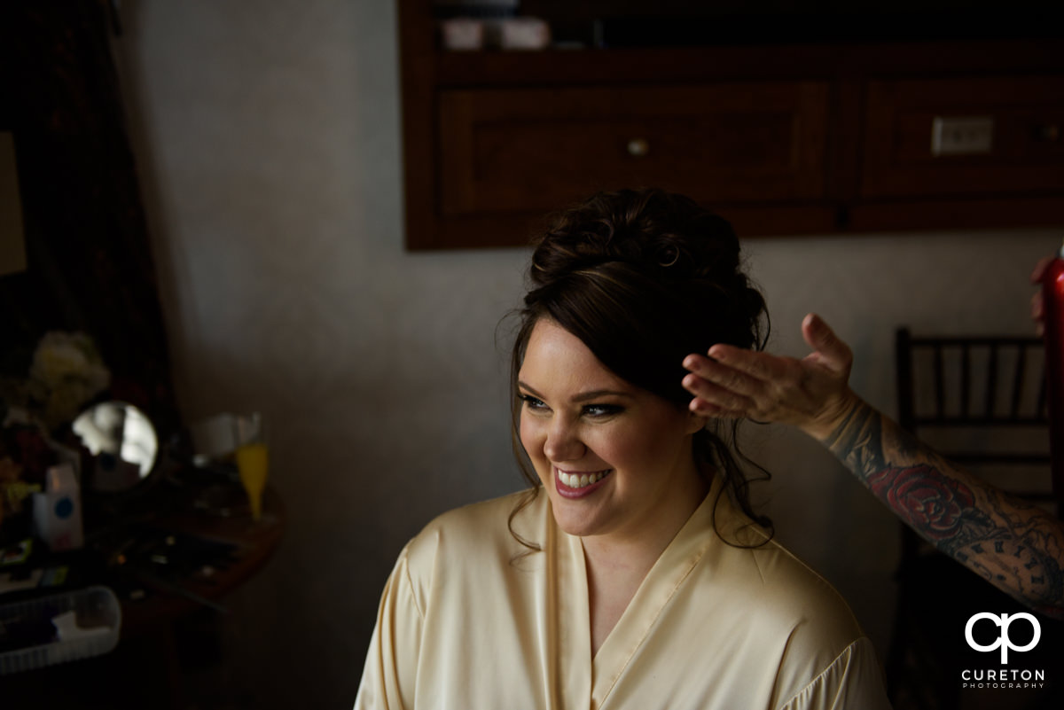 Bride having her hair done on her wedding day.