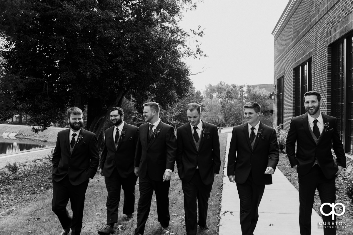 Groomsmen walking down a path together.