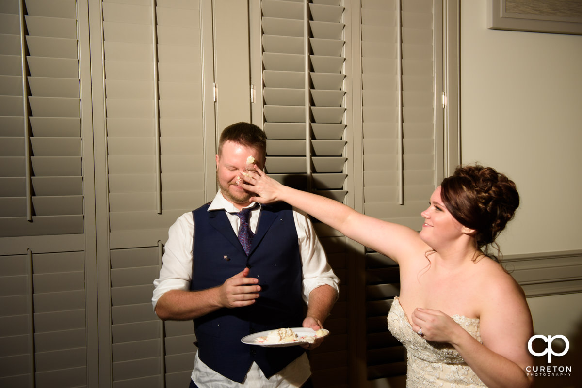 Bride smashing cake on the groom's face.