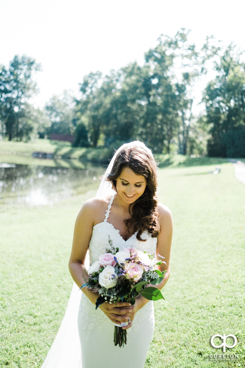 Bride looking at her flowers before her wedding at Noah's Event Venue in Greenville,SC.