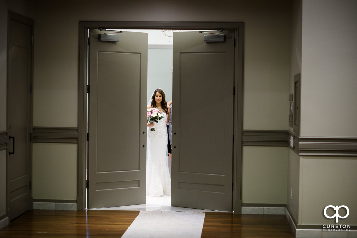 Bride smiling as she makes her grand entrance down the aisle at Noah's Event Venue in Greenville,SC.