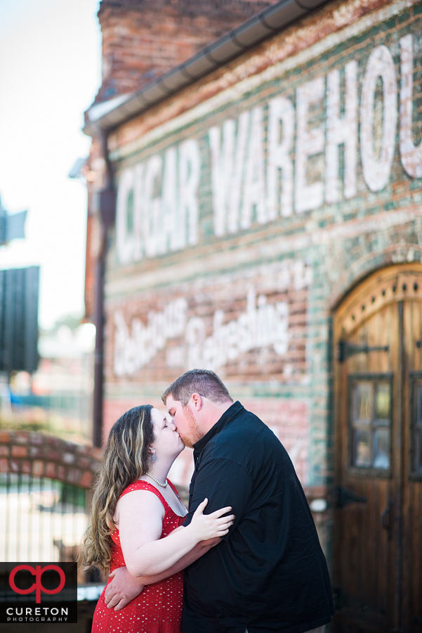 Future bride and groom kissing during their Old Cigar Warehouse engagement session.
