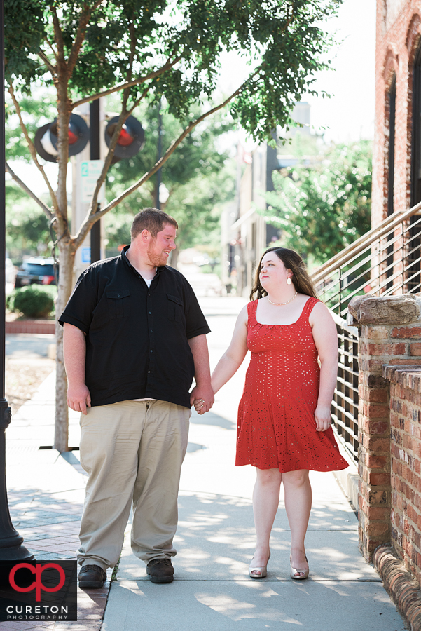 Engaged couple walking down Main St in downtown Greenville,SC.