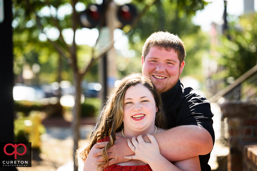 Couple hugging in front of the Old Cigar Warehouse in downtown Greenville SC.