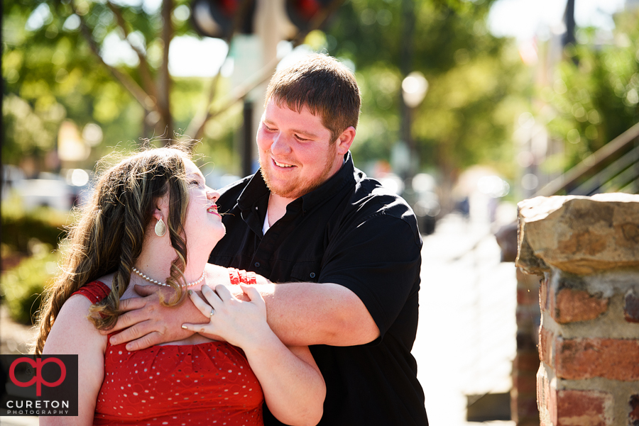 Engaged couple looking at each other in downtown Greenville.