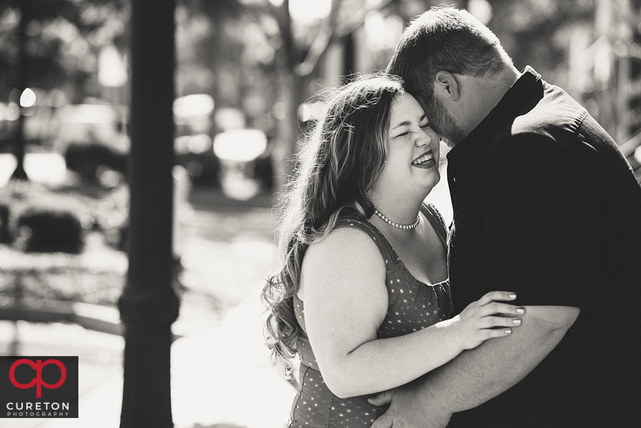 Engaged couple laughing.