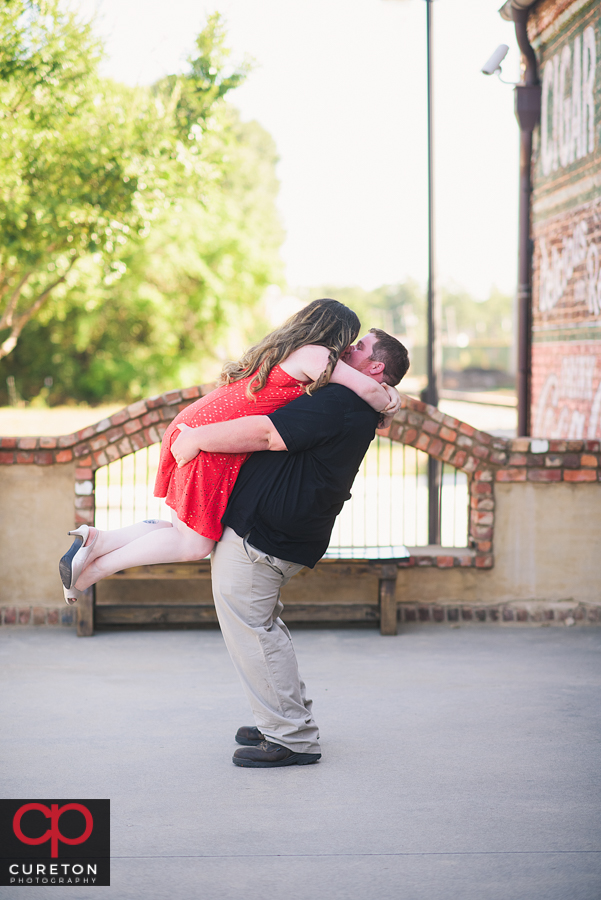 Groom lifting his future bride on the deck at Old Cigar Warehouse.