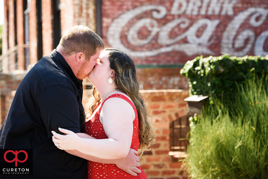 Engaged couple kissing.