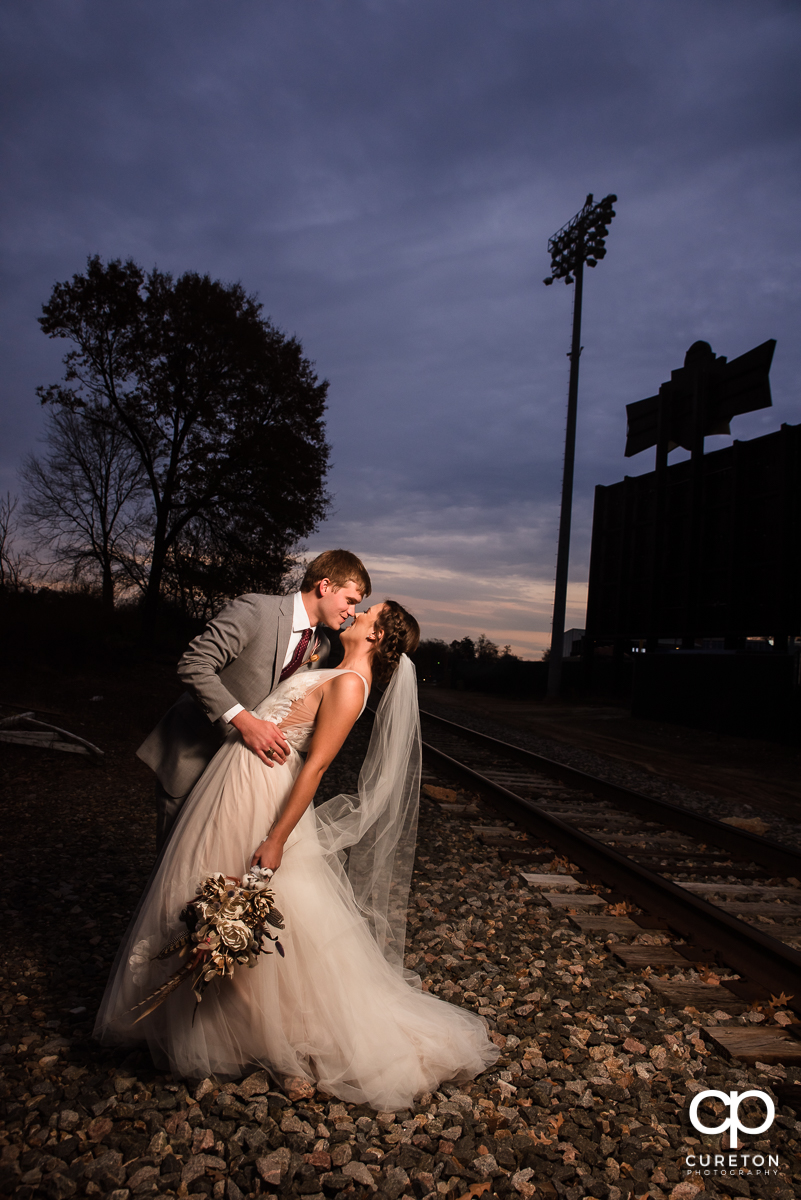 Groom dipping his bride at sunset at their wedding ceremony at The Old Cigar Warehouse in Greenville,SC.