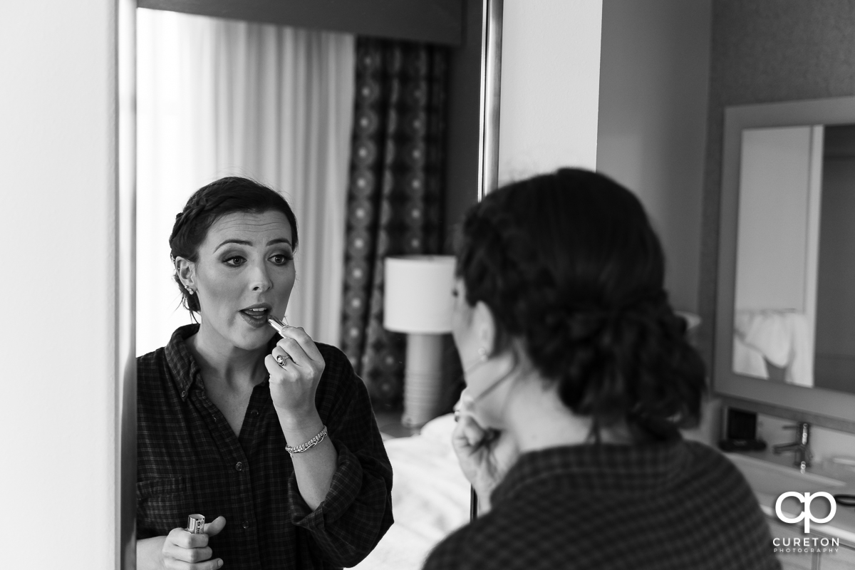 Bride putting makeup on.