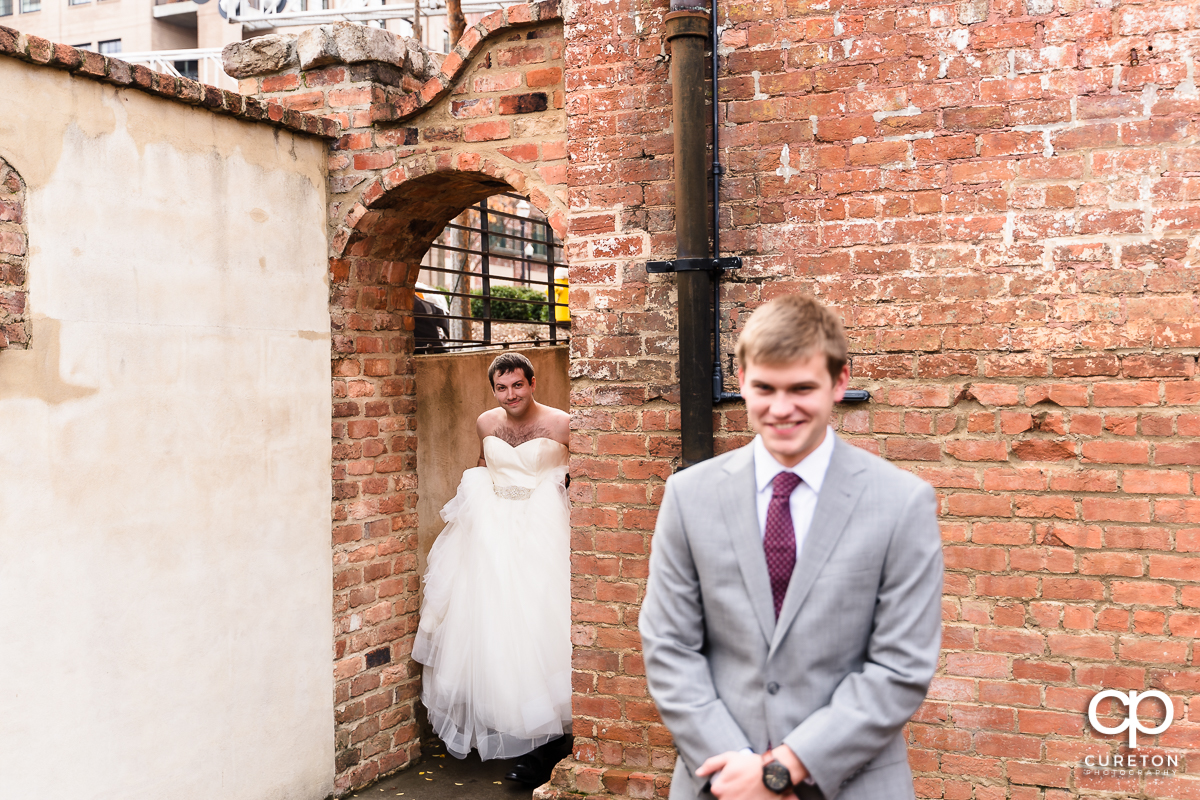 Groomsmen in a wedding dress showing up to the first look to trick the groom.