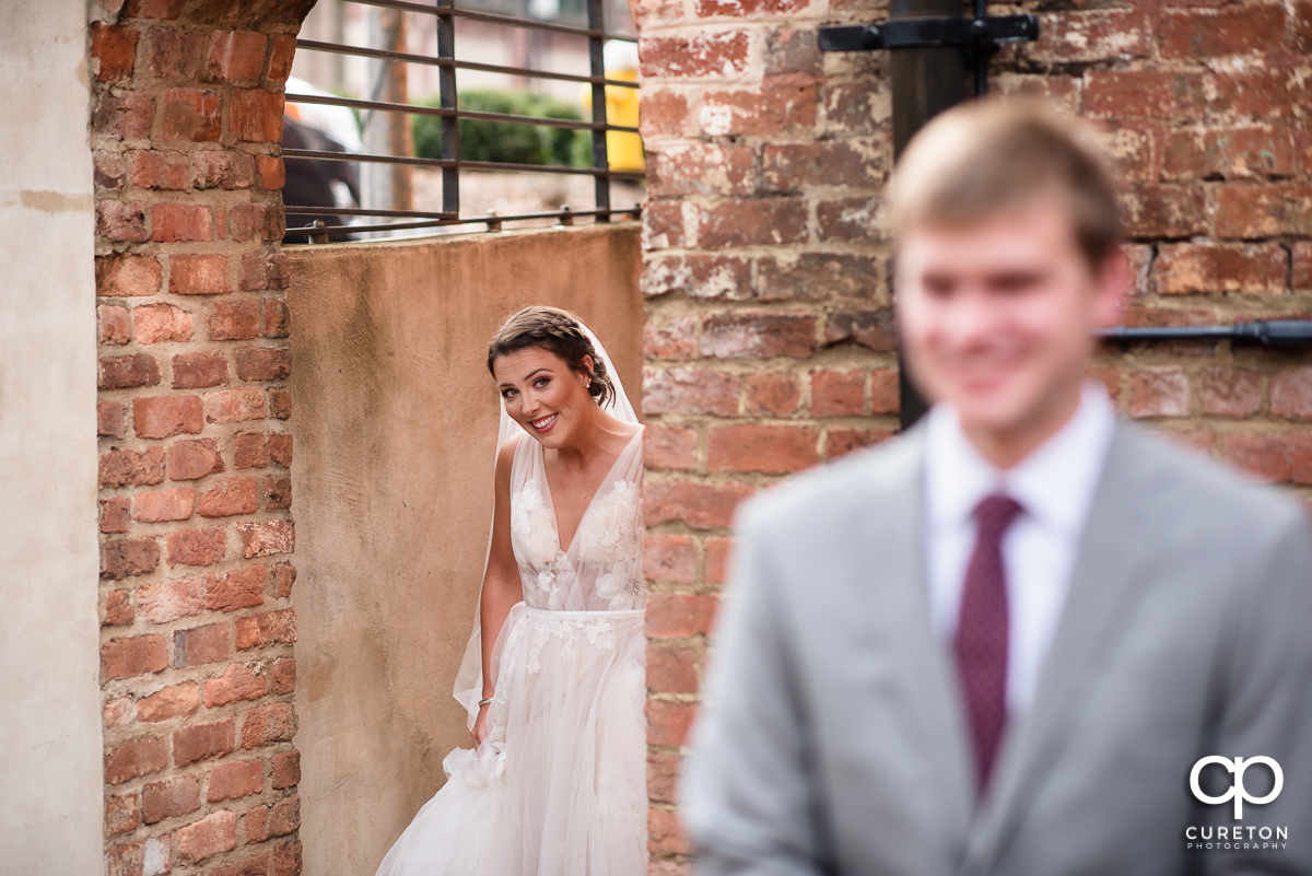 Bride sneaking up on the groom for a first look before the Old Cigar Warehouse wedding.