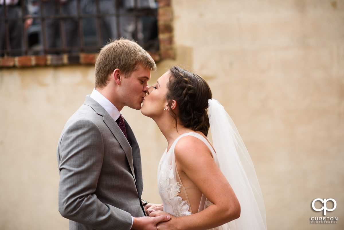 Bride kissing the groom at the first look at The Old Cigar Warehouse.