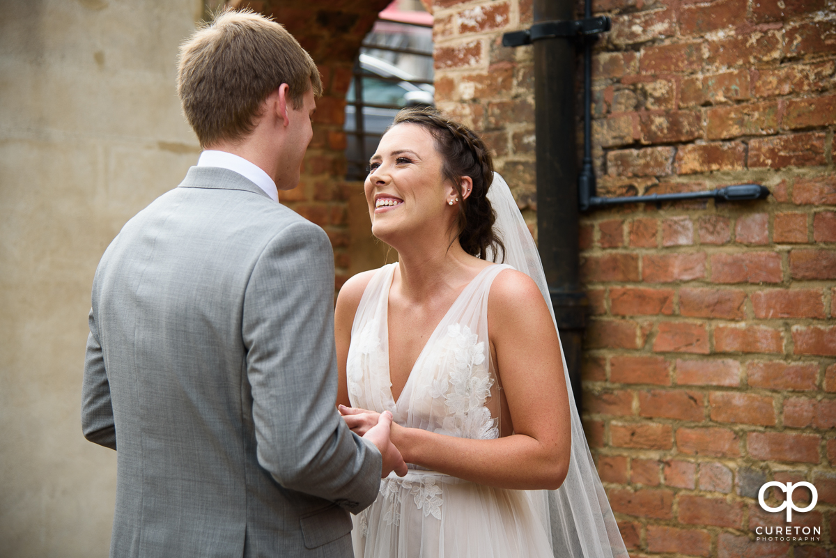 Bride smiling at the groom during a pre-wedding first look at The Old Cigar Warehouse.