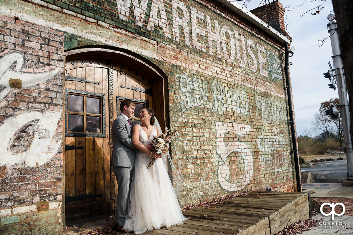 Bride and groom hugging on the back deck of The Old Cigar Warehouse before their wedding.