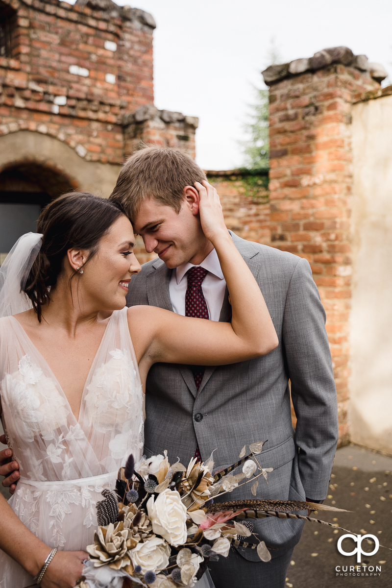 Bride holding her groom.