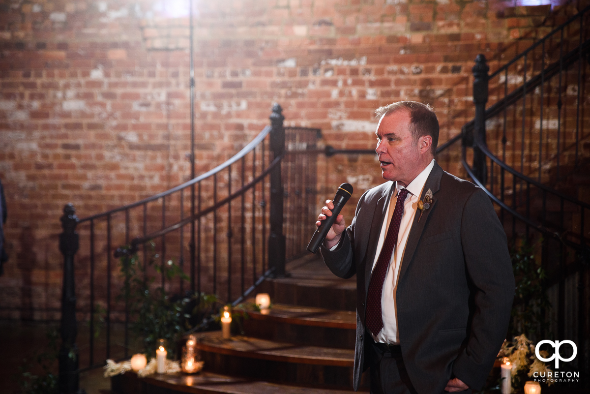 Bride's father saying a prayer at the reception.